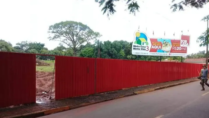 Tapume metálico vermelho em fechamento de terreno