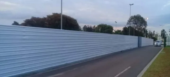 Tapume metálico branco ao longo de uma via